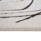 Ivory area rug showing short textured pile and black stitched geometric border lines