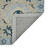 Hand-hooked light blue floral area rug with stitched border edge, navy accents