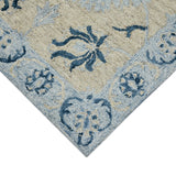 Light blue floral rectangle area rug corner with navy botanical motifs