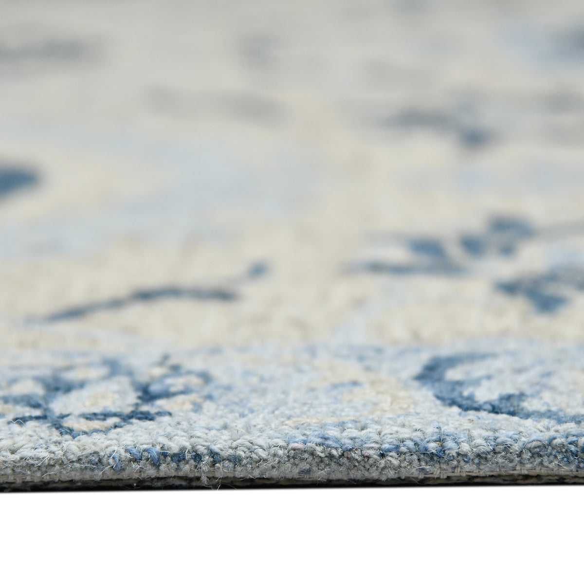Light blue floral area rug surface with textured pile and scattered navy motifs