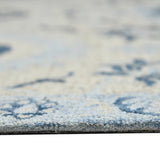 Light blue floral area rug surface with textured pile and scattered navy motifs