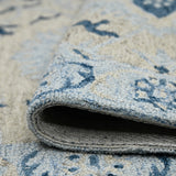 Light blue rug edge with woven underside and stitched border, navy-and-cream pattern