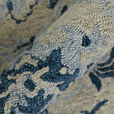 Detail of light blue and cream floral area rug with navy accents and hand-hooked pile
