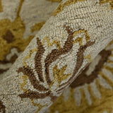 Hand-hooked floral area rug with beige ground and gold-brown curving vines