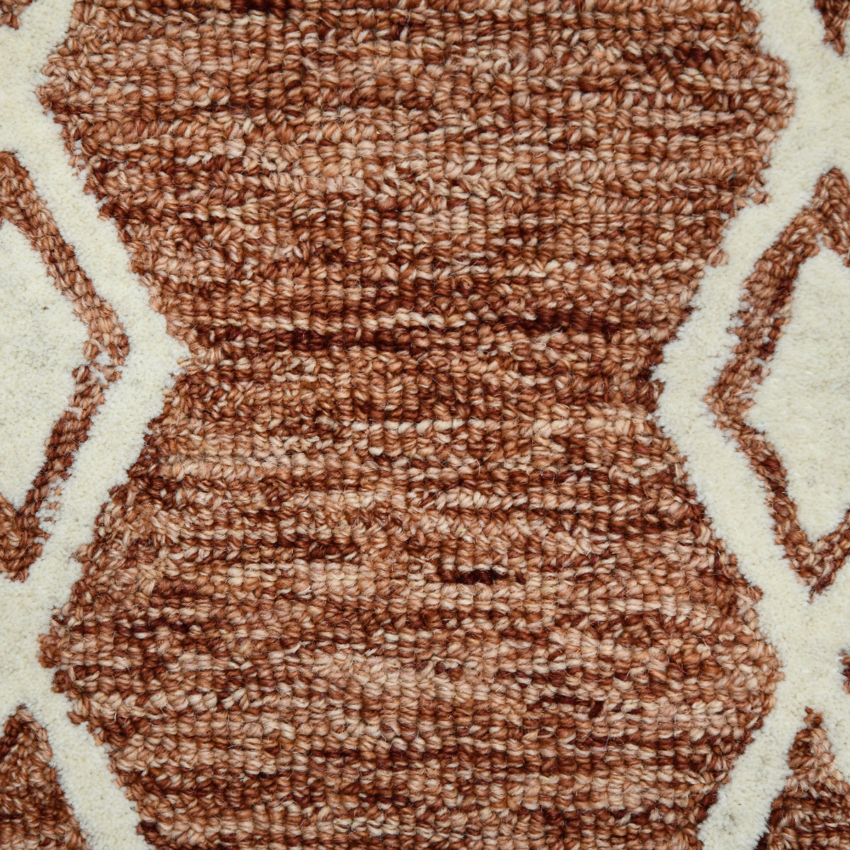 Textured rust geometric rug with cream background and interlocking diamond lines