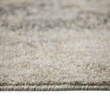 Close-up of rug border with layered edge stitching on beige and gray fibers.
