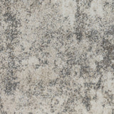 High-detail view of gray and beige abstract distressed rug pattern on short pile.