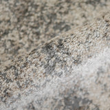 Close-up texture of gray and beige area rug with short, dense loop pile.