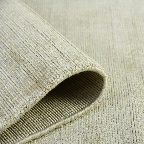 Sand area rug rolled edge with visible binding and looped weave texture.