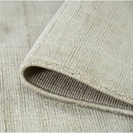 Rectangle area rug showing folded edge and dense striped weave in light sand tones.