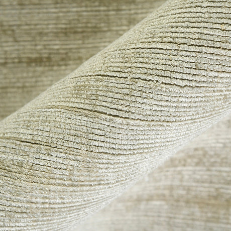 Striped hand-woven area rug corner with close-up texture and light sand color.