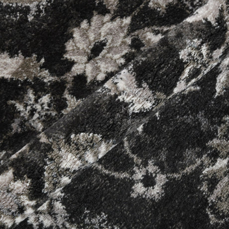 Black and ivory area rug texture close-up with faded motif pattern