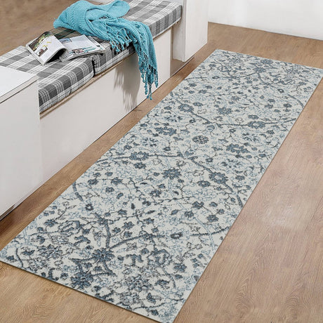 Light blue rectangular floral area rug with intricate damask pattern on wood floor