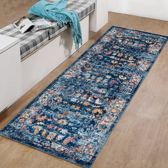 Rectangular navy distressed area rug with colorful border and faded motif center