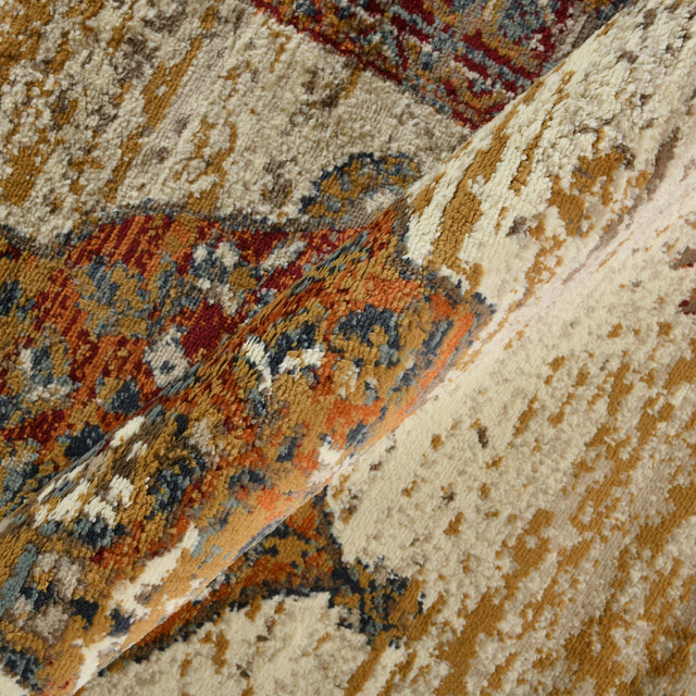 Beige area rug close-up with rust, teal, and blue abstract motif and textured weave.