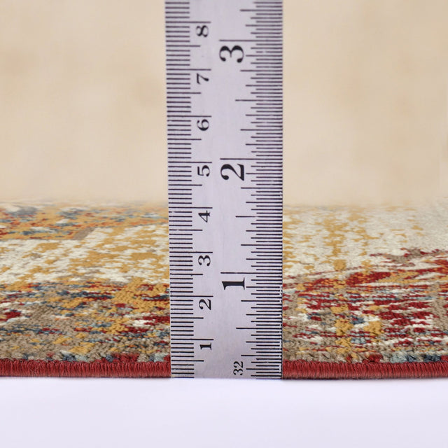 Beige area rug edge shown with measuring ruler above the border, red binding visible.