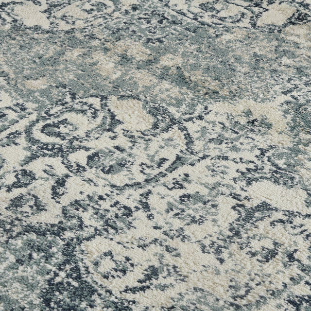 Blue and ivory area rug with distressed medallion and swirling motifs