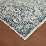 Ivory and blue area rug corner with distressed medallion pattern