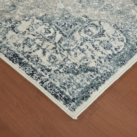 Ivory and blue area rug corner with distressed medallion pattern