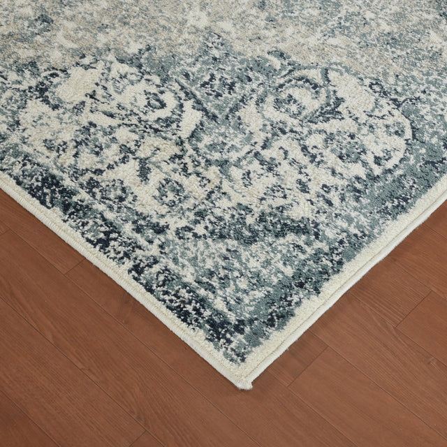 Ivory and blue area rug corner with distressed medallion pattern
