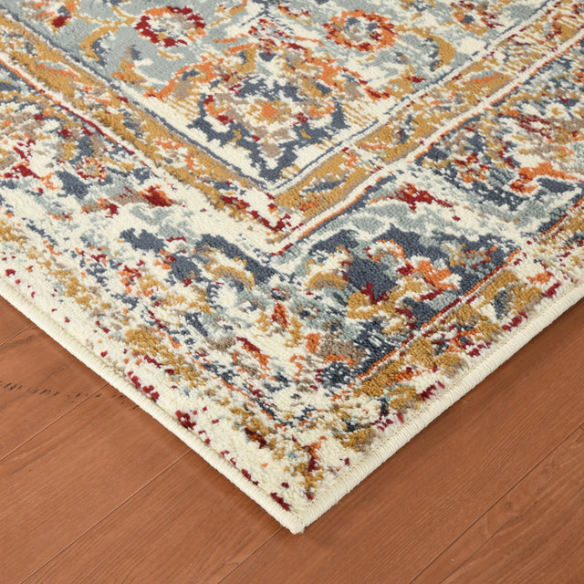 Ivory and navy medallion area rug corner with border trim on hardwood floor