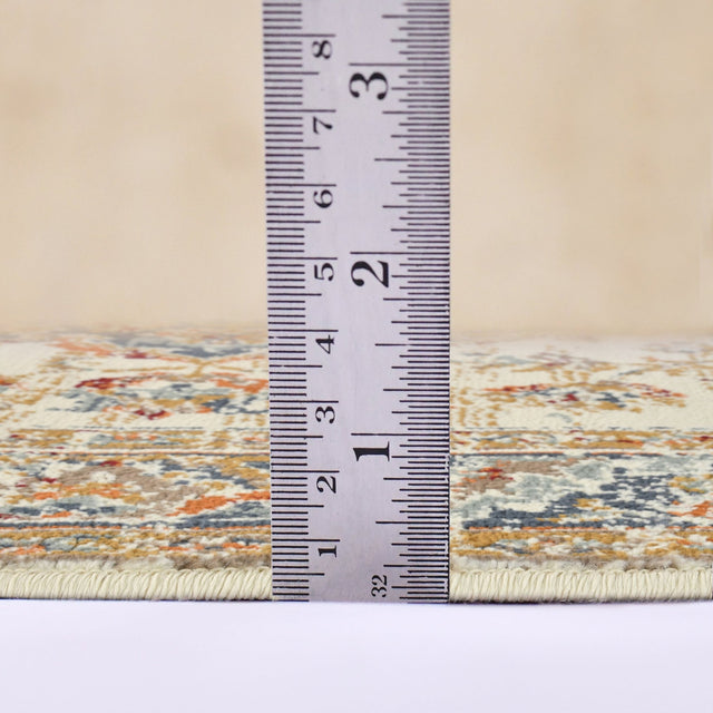 Ivory and navy area rug edge with measuring tape showing low pile height