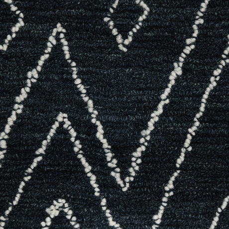 Rectangular area rug close-up of raised looped weave in dark navy-charcoal with white pattern