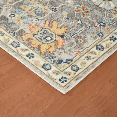 Gray rectangular area rug with border trim, multicolor floral medallions on hardwood floor