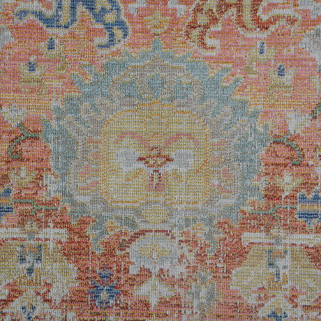 Close-up medallion pattern area rug in blue, coral, and ivory