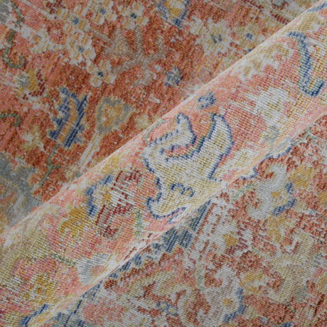 Textured area rug with scrolling medallion detail in coral and blue