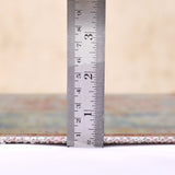 Area rug edge with fringe, shown with measuring ruler for pile thickness