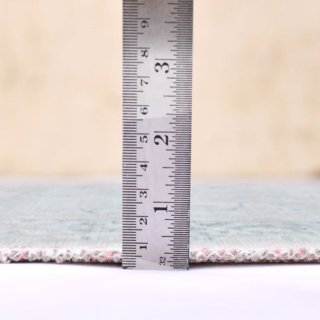 Sea mist area rug edge shown with measuring ruler at the rug border