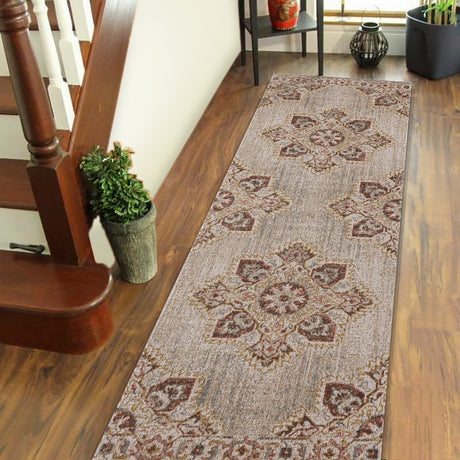 Beige and sand area rug with ornate medallion motif, shown laid on wood floors