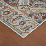 Beige area rug corner with distressed geometric medallion pattern and short fringe