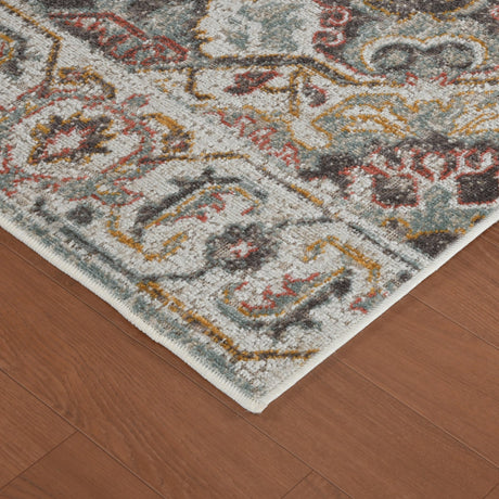 Beige area rug corner with distressed geometric medallion pattern and short fringe