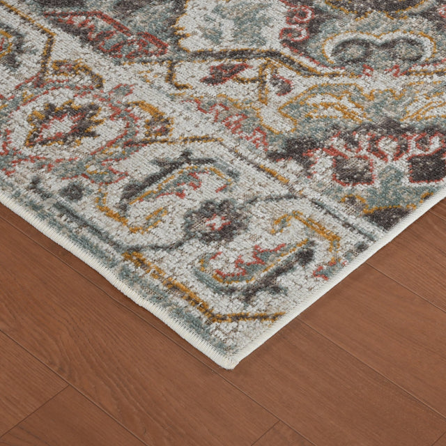 Beige area rug corner with distressed geometric medallion pattern and short fringe
