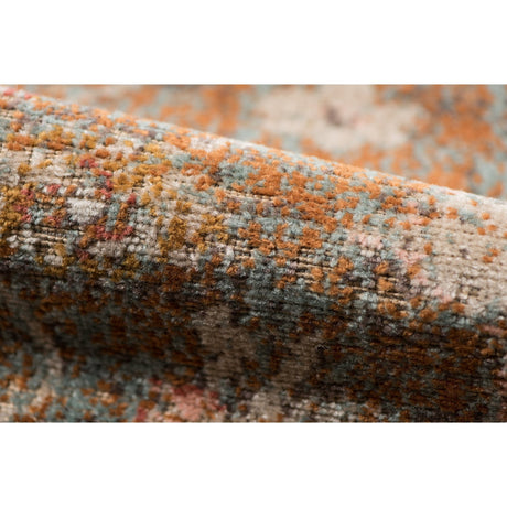Textured edge of taupe medallion area rug with distressed multicolor woven pile