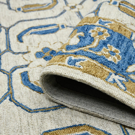 Hand-hooked floral area rug corner with rolled edge and gray underside visible