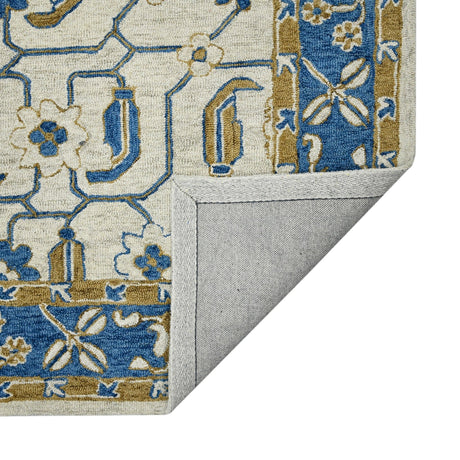 Hand-hooked floral area rug with cream base, royal blue pattern, and gray backing at corner