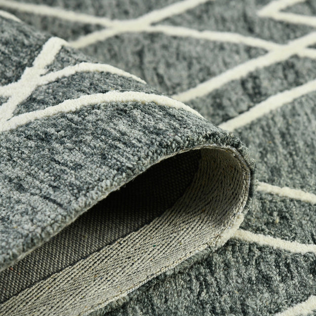 Rolled edge detail: gray rug with off-white lines and textured weave binding
