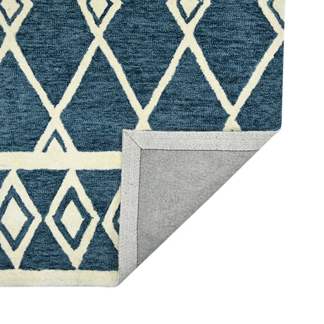 Corner view of navy geometric area rug with cream pattern and folded edge binding