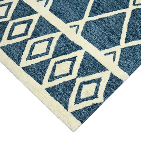 Lower corner of navy rug with cream diamond and lattice motif on textured surface