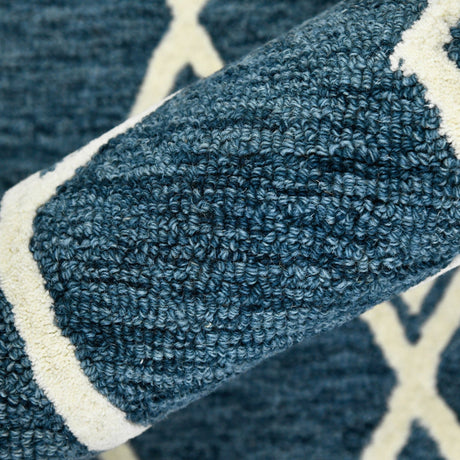 Close-up of navy rug corner with cream border and dense looped pile texture
