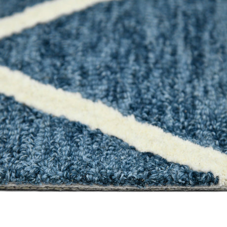 Close-up along rug edge with navy chenille-like pile and cream border stripe