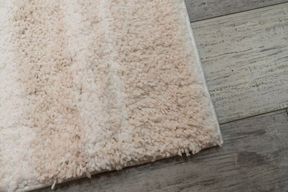 Ivory and beige shag rug with thick plush pile and neatly bound corner edge
