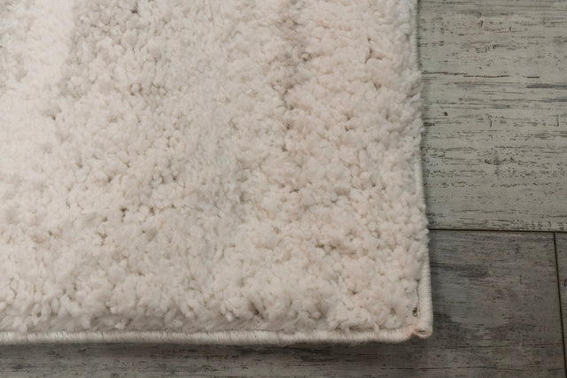Light grey rectangular shag rug with plush looped texture, detailed corner edge