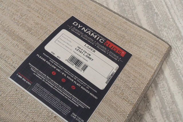 Light grey power-loomed rectangle rug with multitone woven texture; brand label attached
