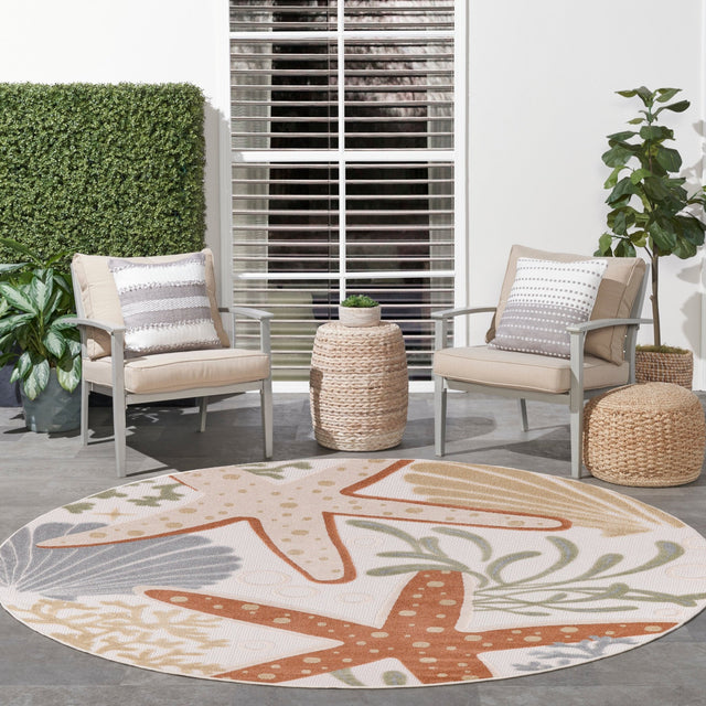 Ivory round rug with large starfish motif and leaf accents in orange and green