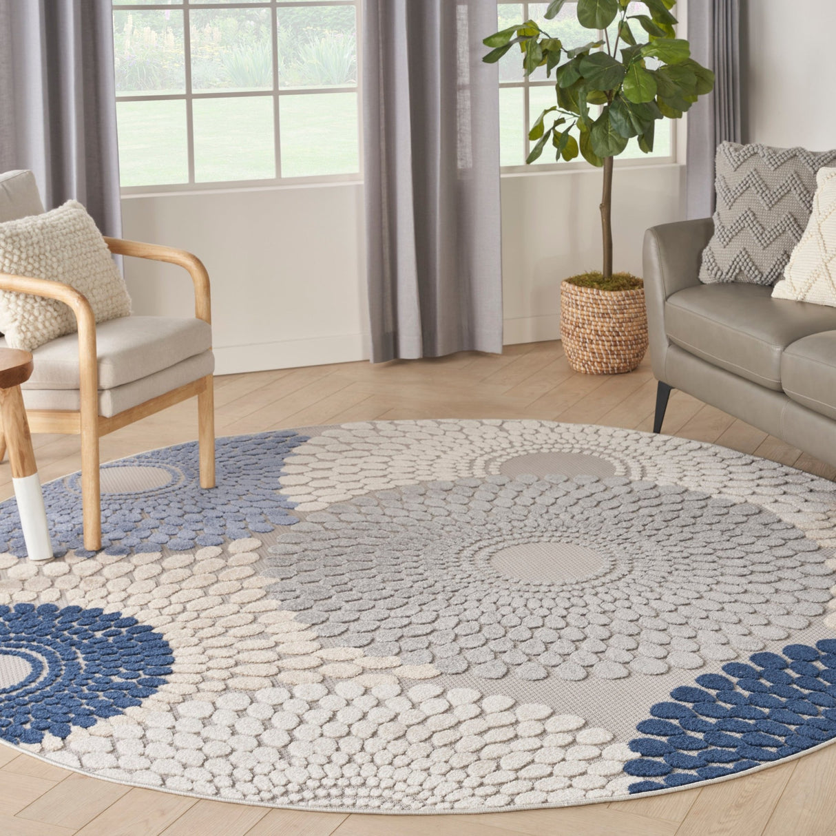 Round area rug with blue and grey geometric medallion pattern and light cream background