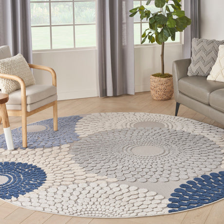 Round area rug with blue and grey geometric medallion pattern and light cream background